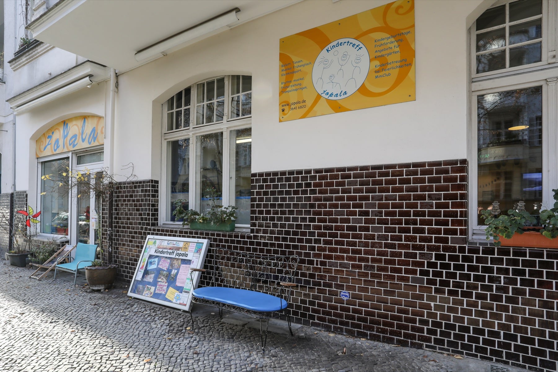 Ladenfront des Kindertreffs jopala mit Sitzbank und Aushang