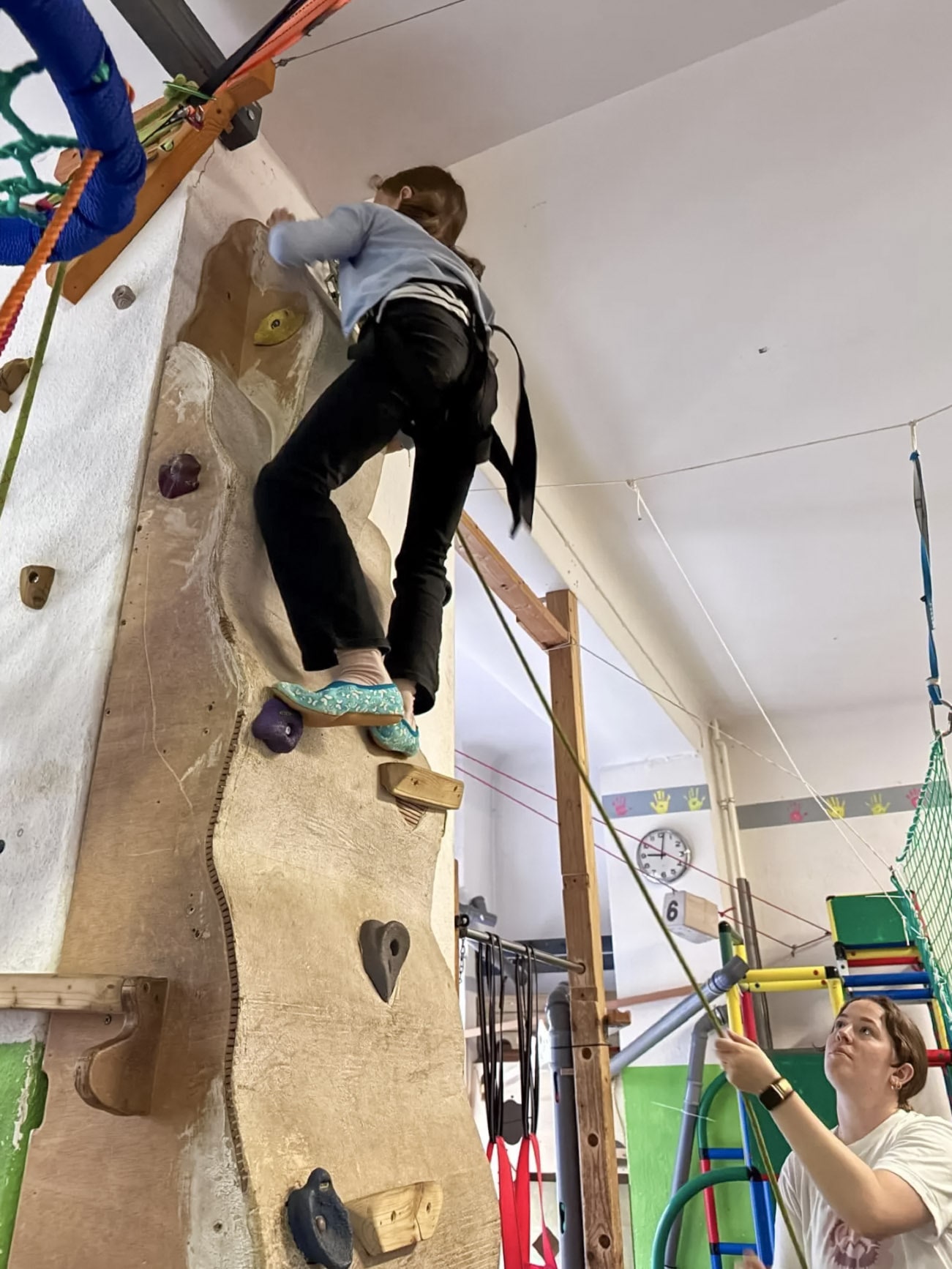 Kind an der Kletterwand mit Begleitung im jopala