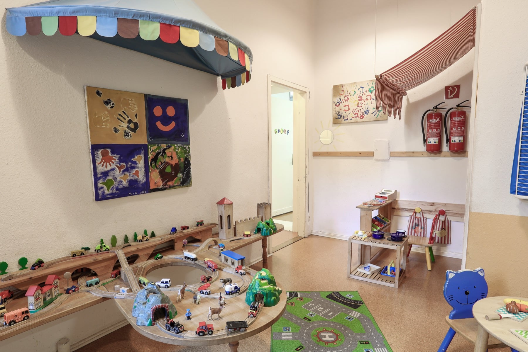 Spielzimmer im jopala mit Holzeisenbahn und Spielteppich
